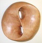Genus 2 surface with a raised edge forming a figure 8 knot, block of cherry wood was 2"x6"x6" by Alex J. Feingold